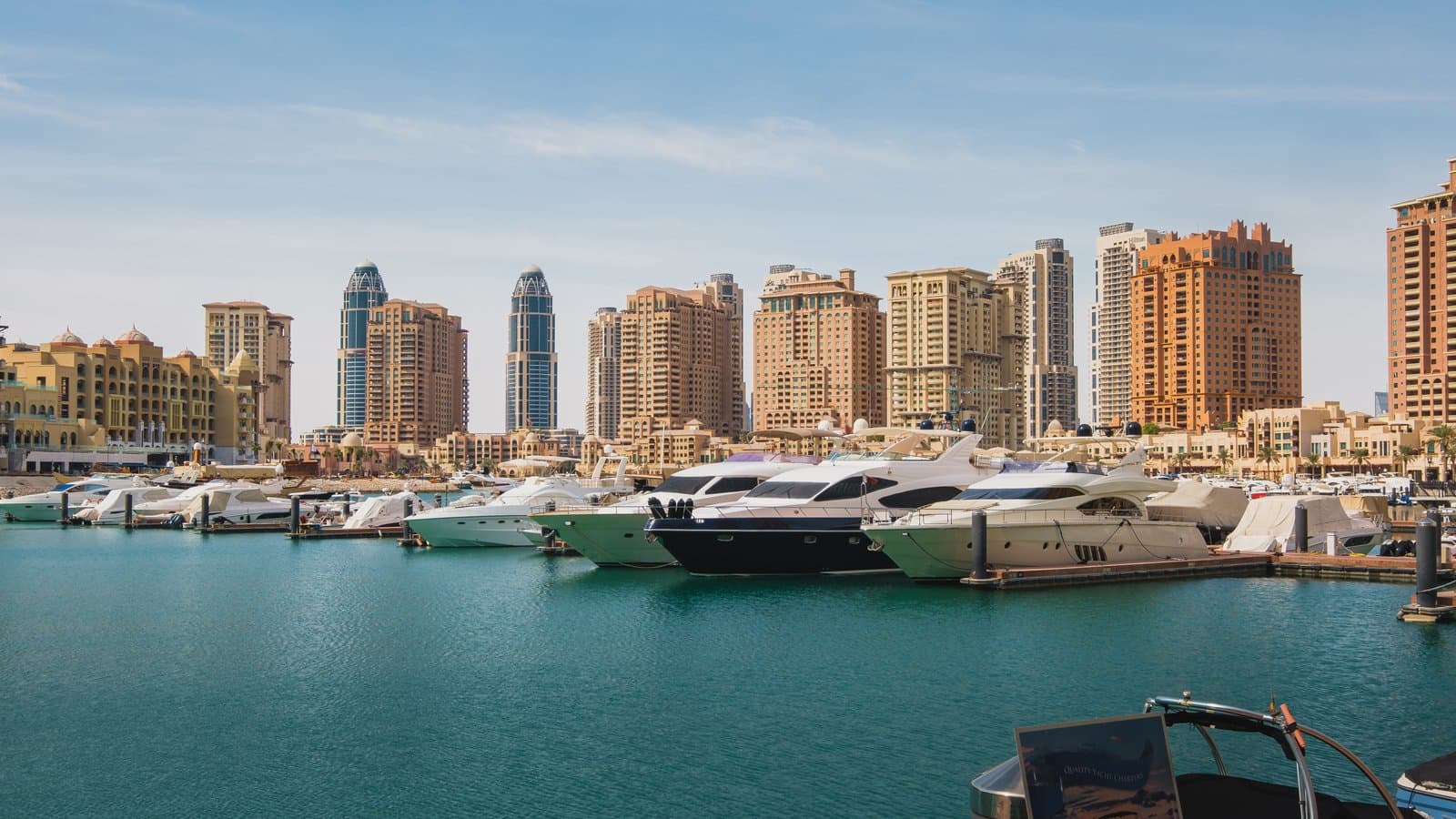 Waterfront apartment towers and a marina full of yachts at The Pearl Island, Doha