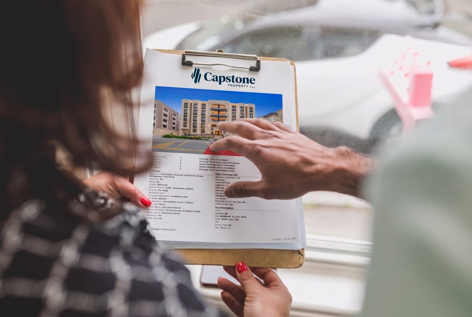 Buyer reviewing property documents and a developer payment plan in Qatar with a Capstone Property advisor.