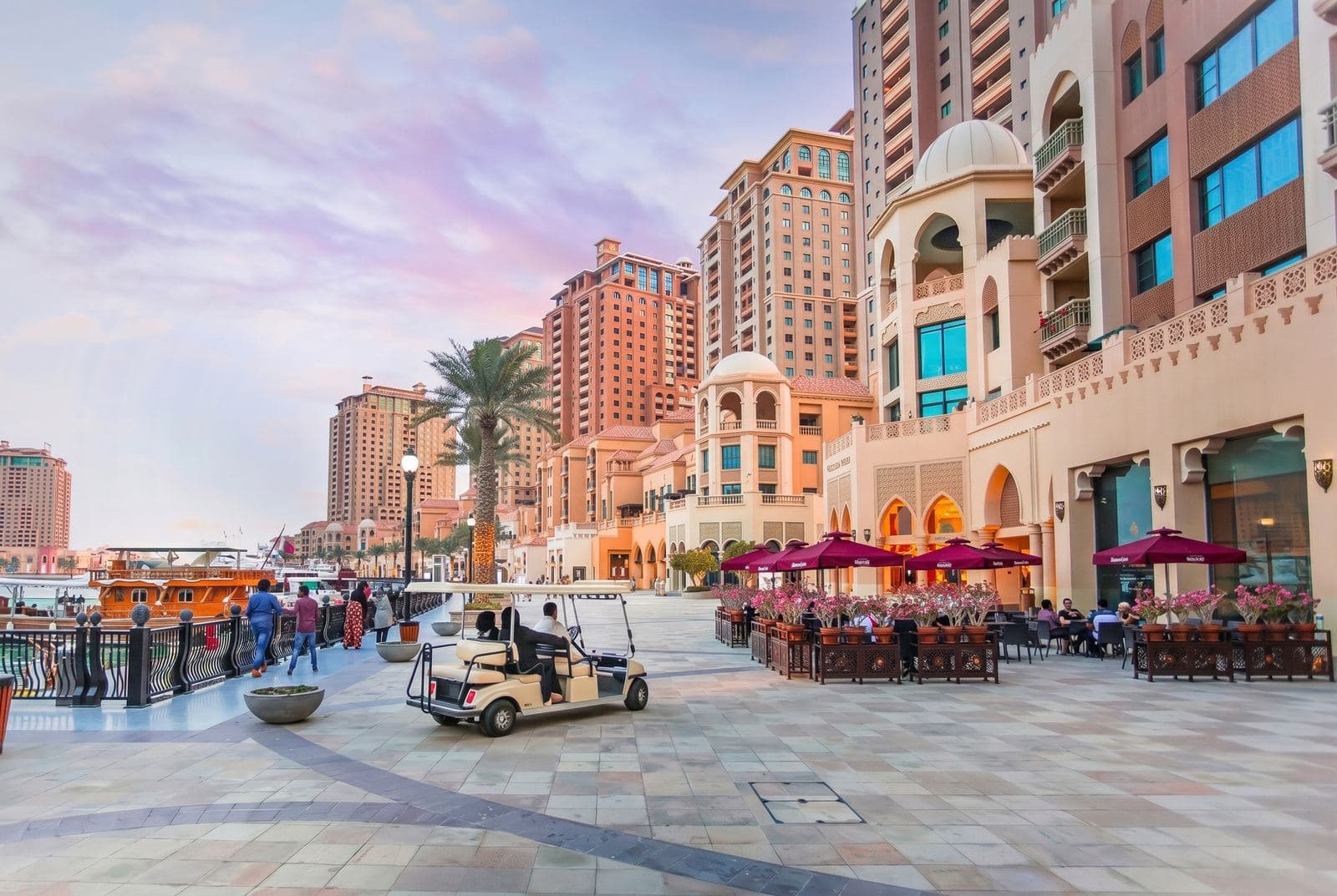 Waterfront promenade at Porto Arabia, The Pearl Island, Doha, with restaurant terraces and residential towers at dusk