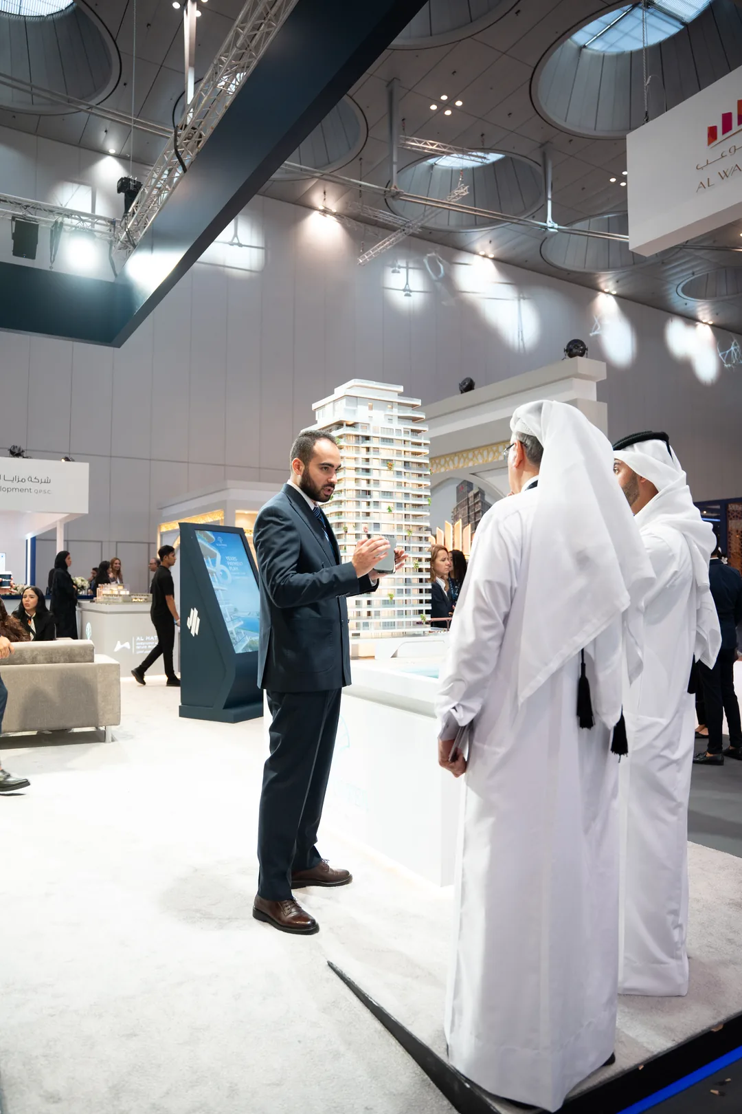 A Capstone Property advisor presenting a project and its payment plan to visitors at Cityscape Qatar, the real estate exhibition in Qatar | مستشار من كابستون للعقارات يعرض مشروعاً وخطة سداده على الزوار في معرض سيتي سكيب قطر، معرض العقارات في قطر